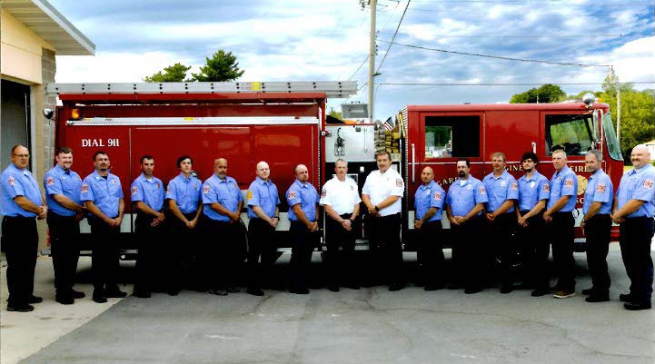 Firefighters standing in front of fire truck