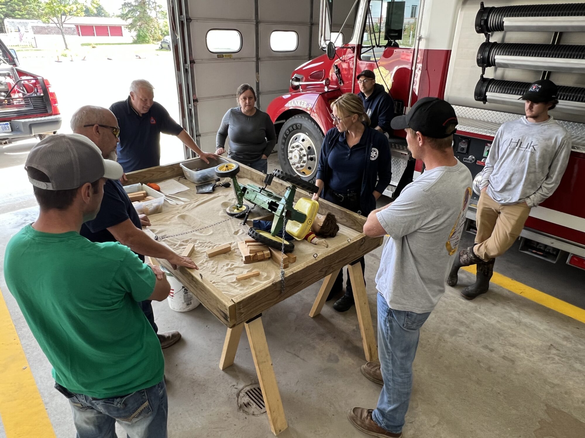 Firefighters training around a table with equipment.