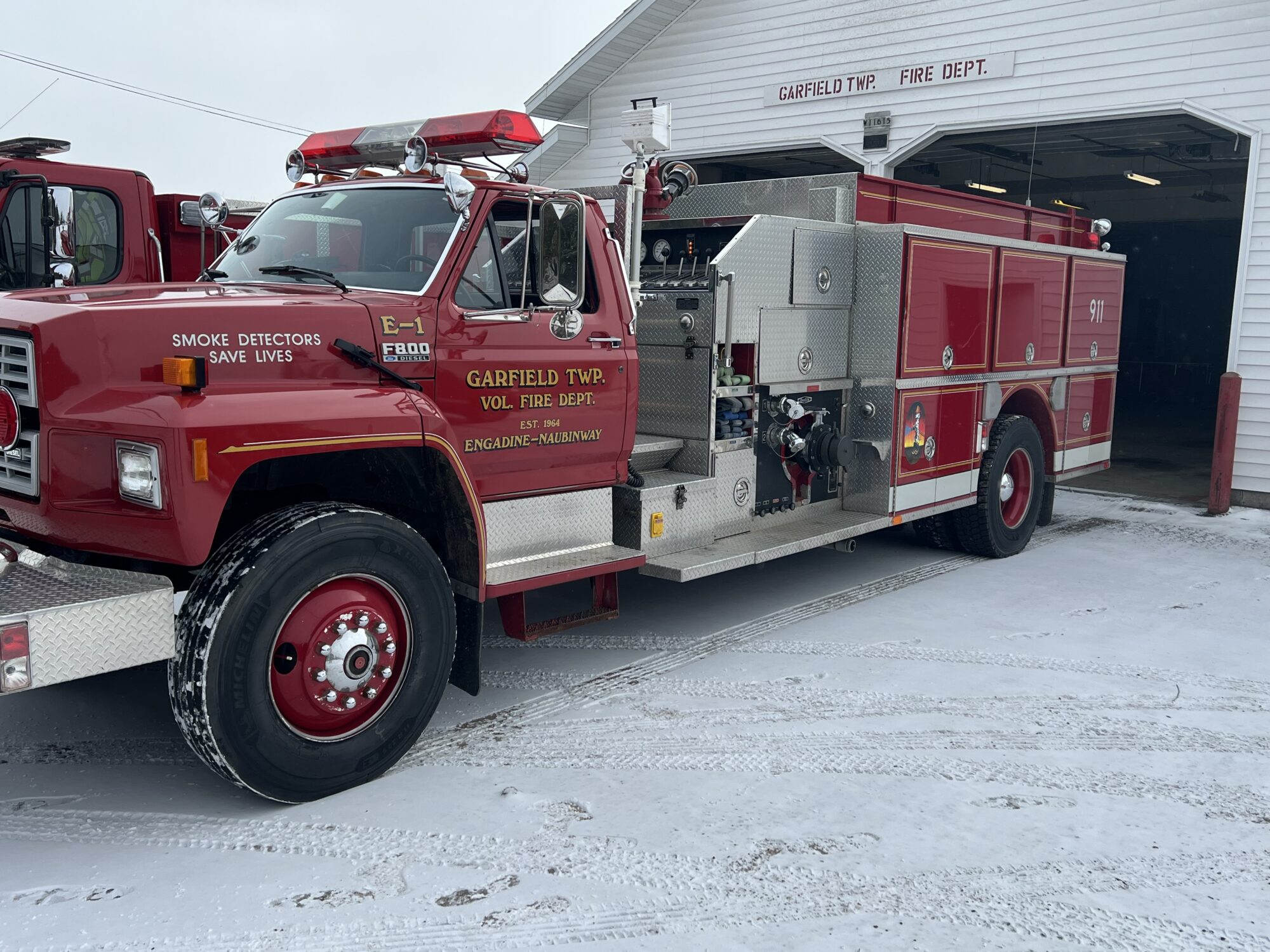 Red fire truck outside a fire department building.