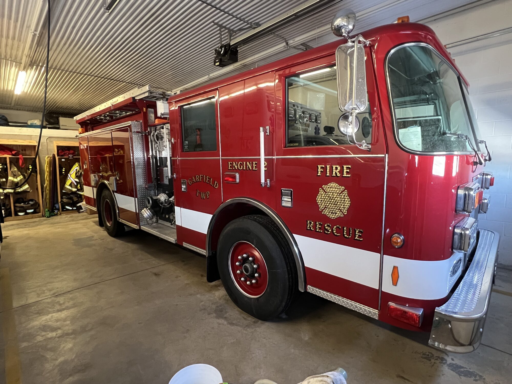 Red fire truck parked inside a fire station.