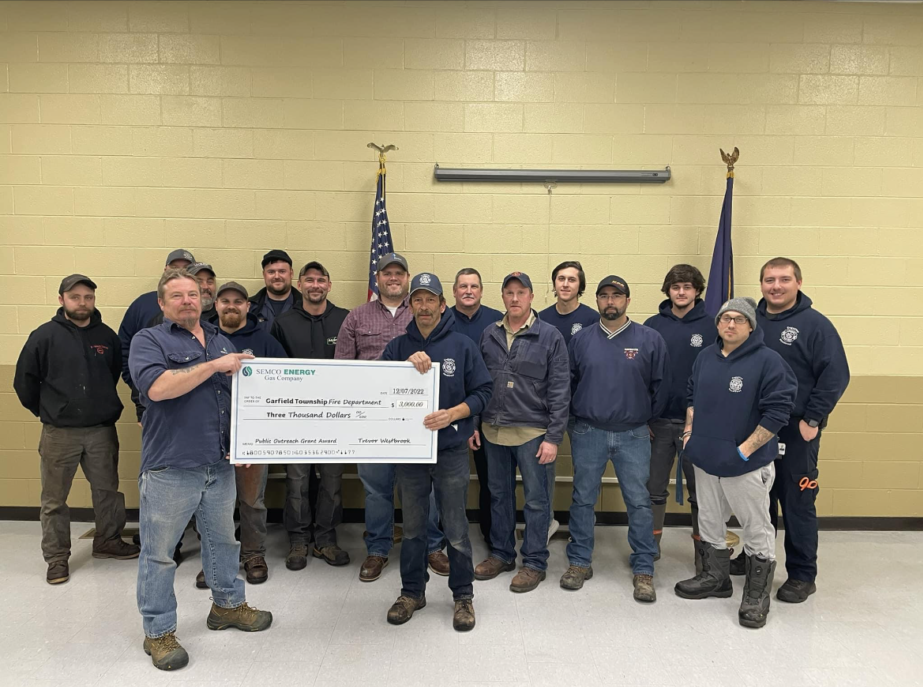 Group holding check, SEMCO Energy donation event.