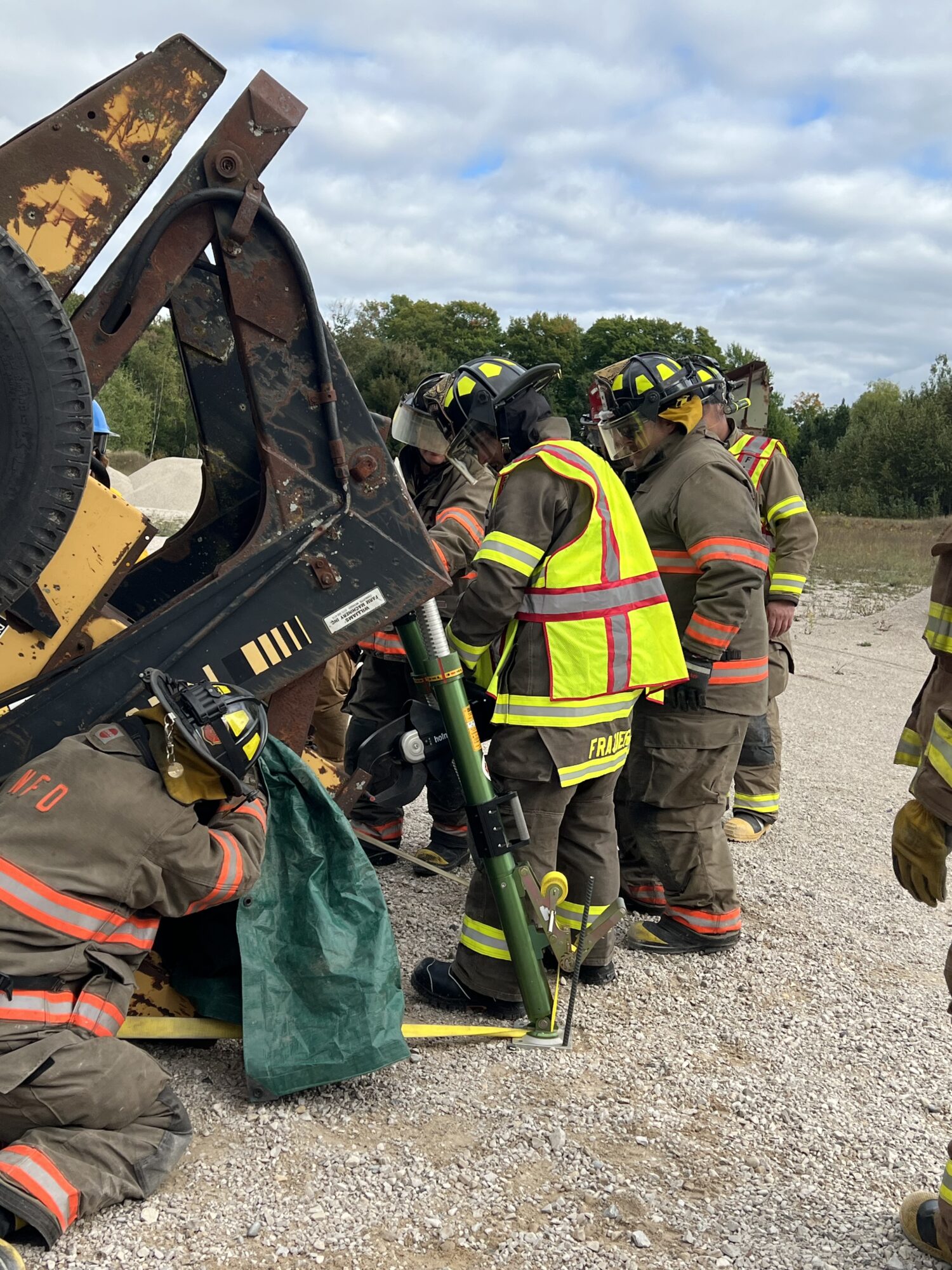 Firefighters training with heavy equipment rescue simulation.