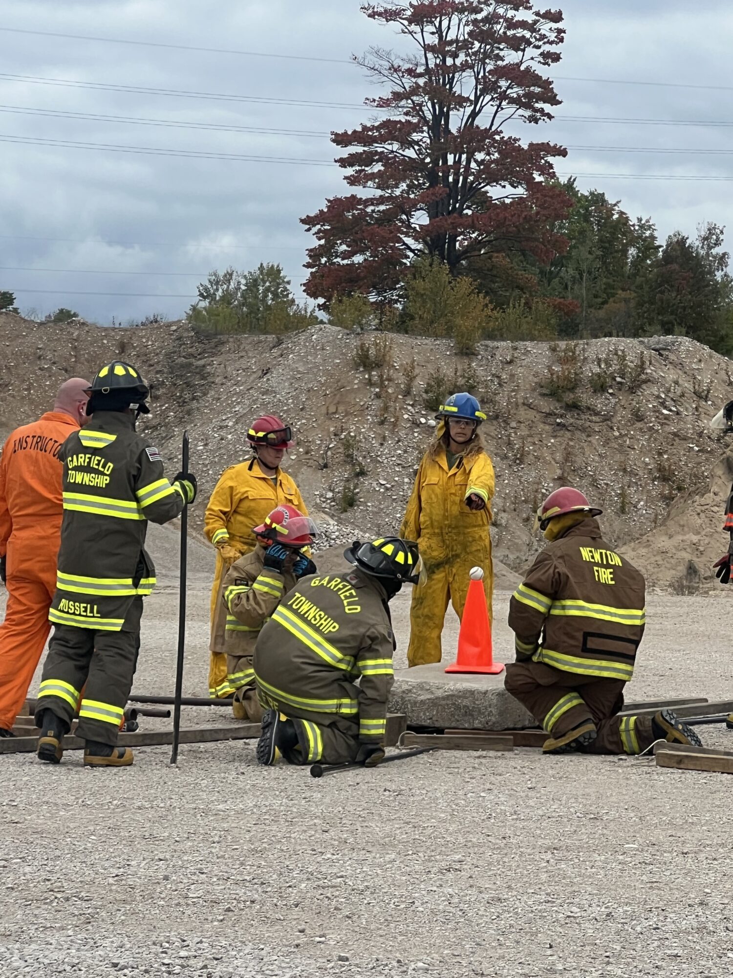 Firefighters in training session with safety equipment.