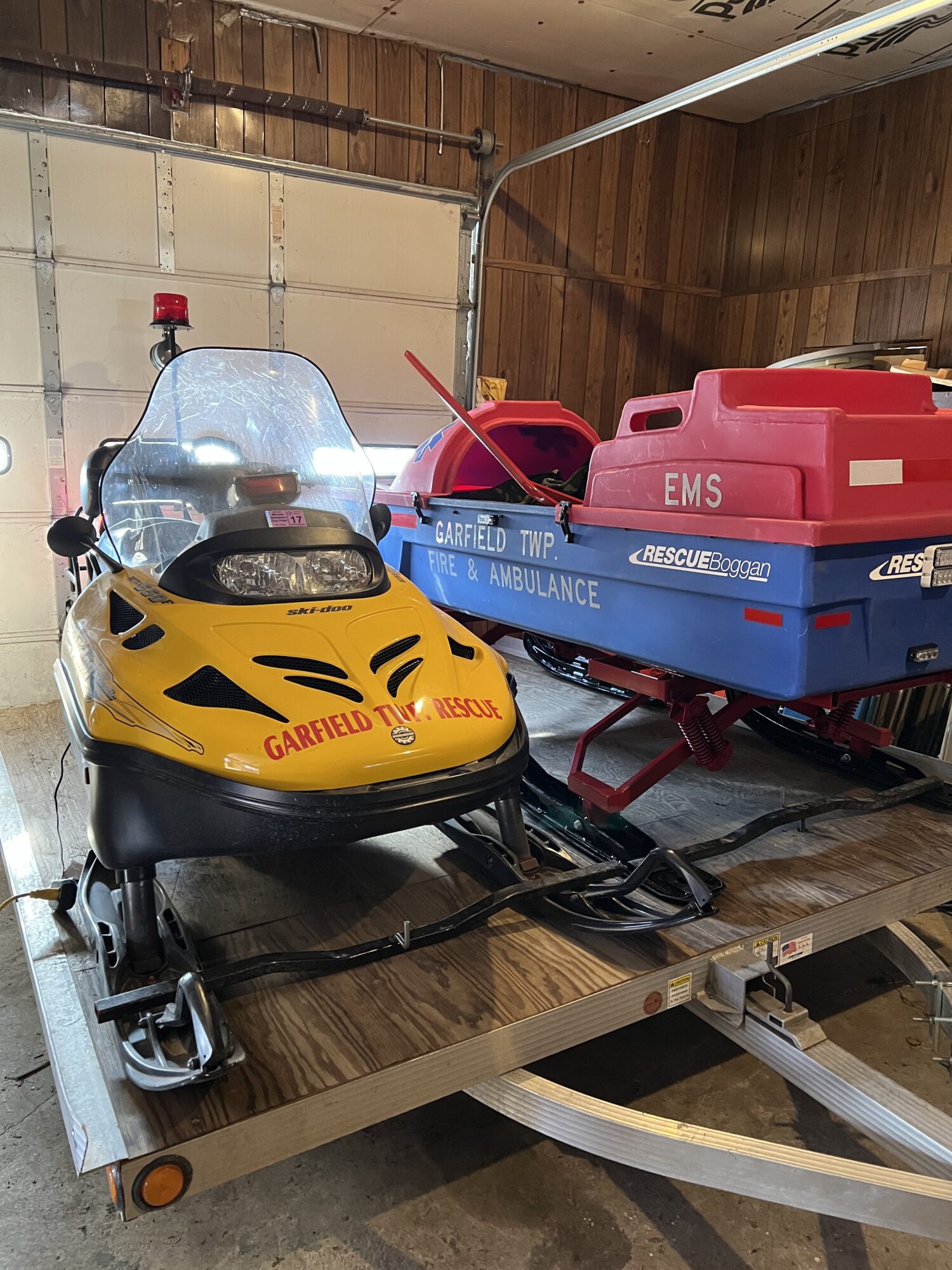 Rescue snowmobile and sled in garage.